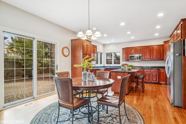 dining space with recessed lighting, light wood-style floors, and a notable chandelier