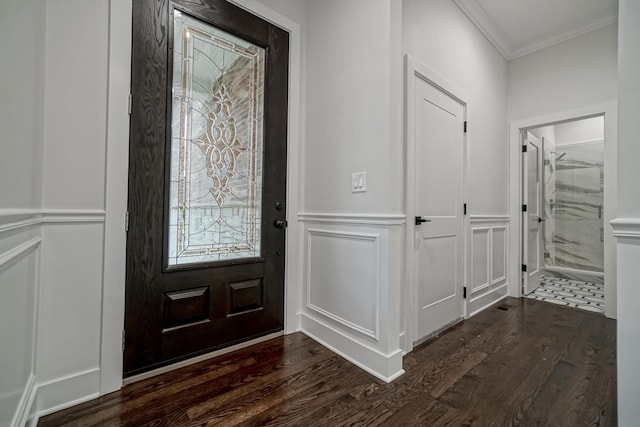 entrance foyer with a decorative wall, crown molding, and dark wood finished floors