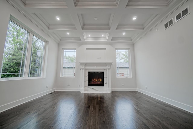 unfurnished living room with a healthy amount of sunlight, coffered ceiling, a premium fireplace, and beam ceiling