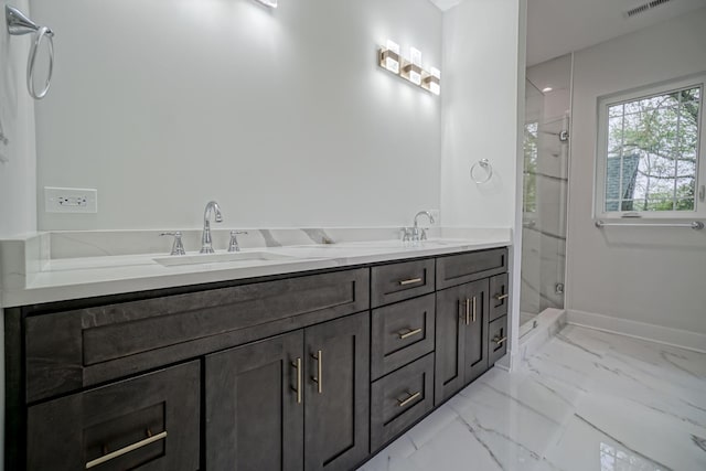 full bath featuring marble finish floor, a sink, a marble finish shower, and baseboards