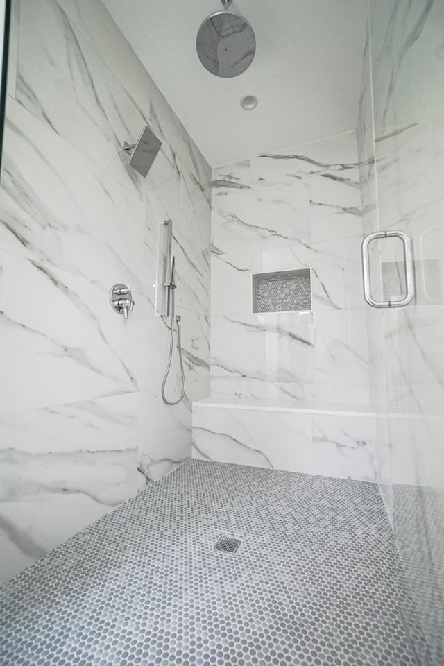 full bathroom featuring a marble finish shower