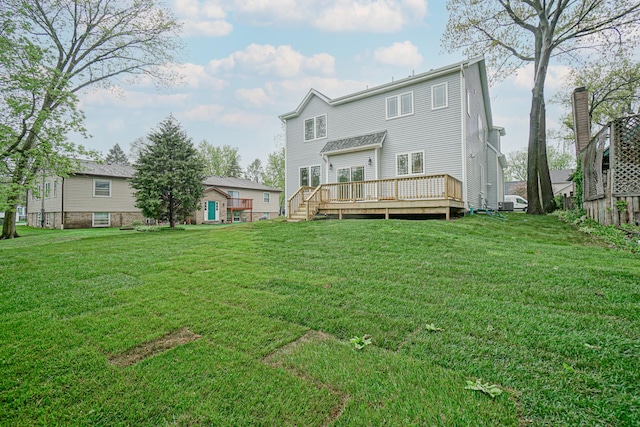 back of house featuring a lawn and a deck