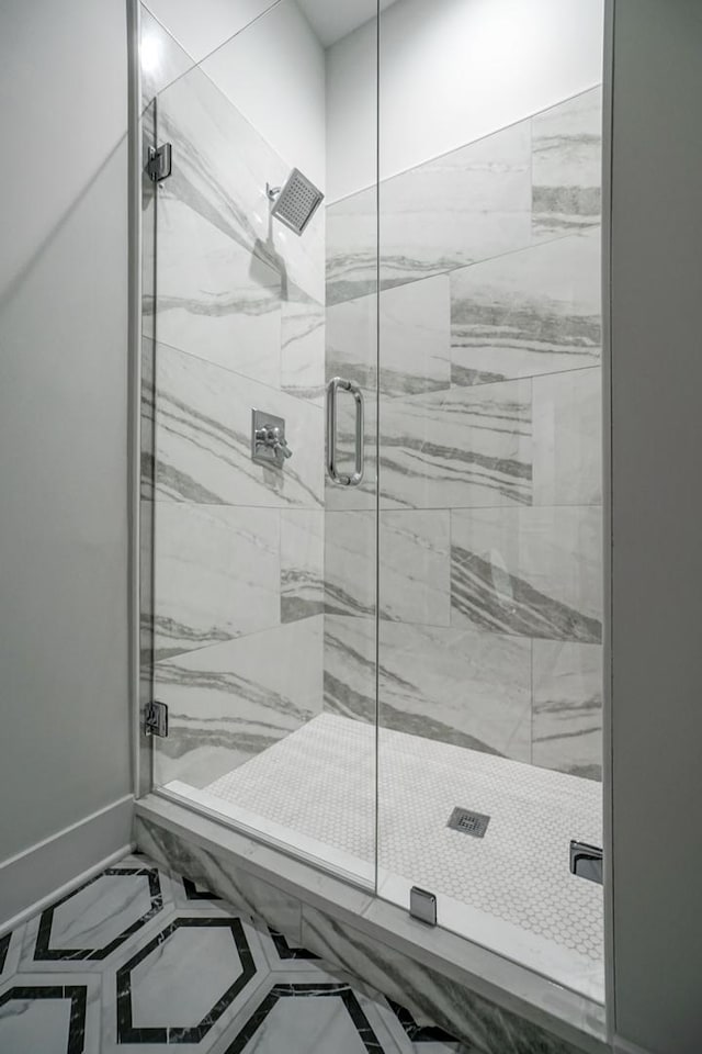 bathroom featuring a stall shower, baseboards, and marble finish floor