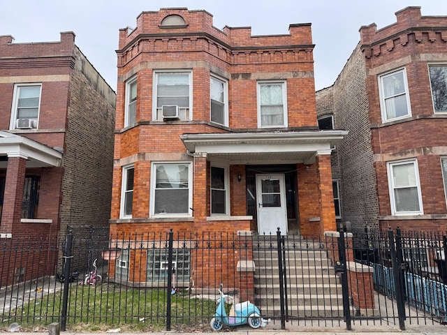view of front facade featuring cooling unit, brick siding, and a fenced front yard
