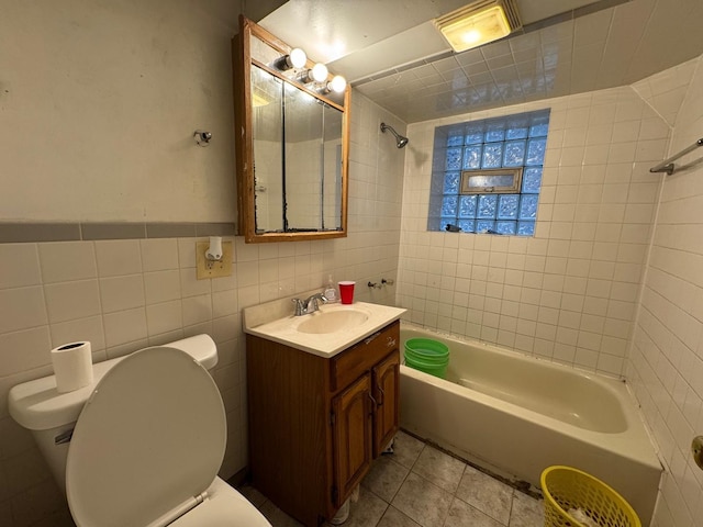 bathroom with tile walls, toilet, tile patterned floors, vanity, and shower / bathing tub combination