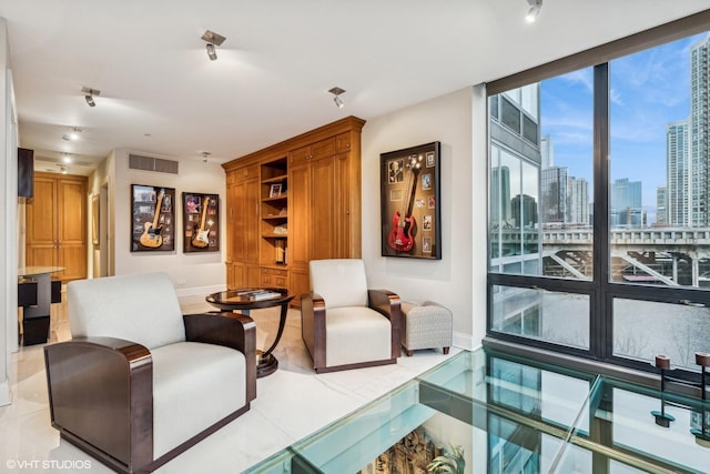 living room with a wall of windows, visible vents, a view of city, and baseboards