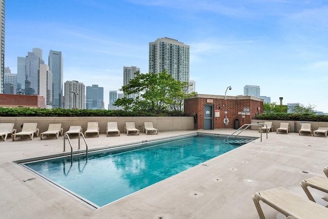 community pool featuring a view of city and a patio