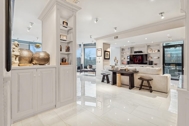interior space with built in features, ornamental molding, and visible vents