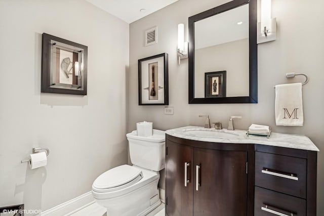 bathroom featuring baseboards, visible vents, toilet, and vanity