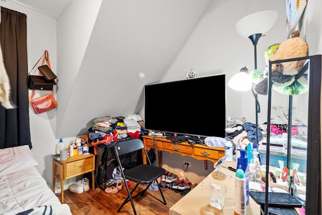 bedroom featuring lofted ceiling and wood finished floors