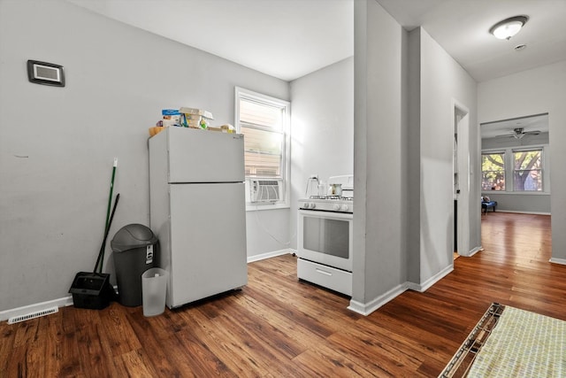 kitchen with white appliances, a ceiling fan, visible vents, baseboards, and wood finished floors