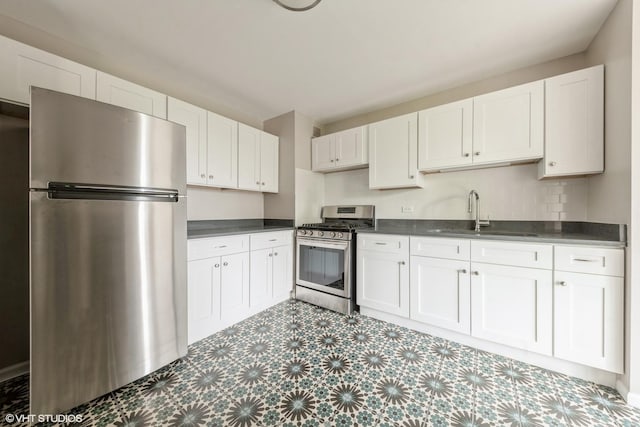 4850 S Lake Park Ave Unit 512, Chicago, IL 60615 - kitchen with stainless steel appliances, a sink, tile patterned floors, dark countertops, and white cabinets