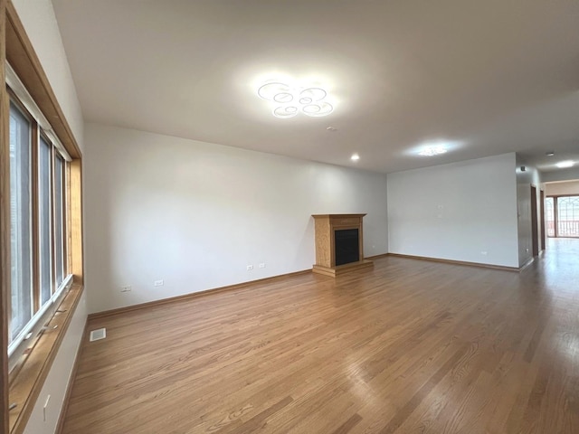 1019 W 47th Pl, Chicago, IL 60609 - unfurnished living room featuring a fireplace, light wood-style floors, baseboards, and visible vents