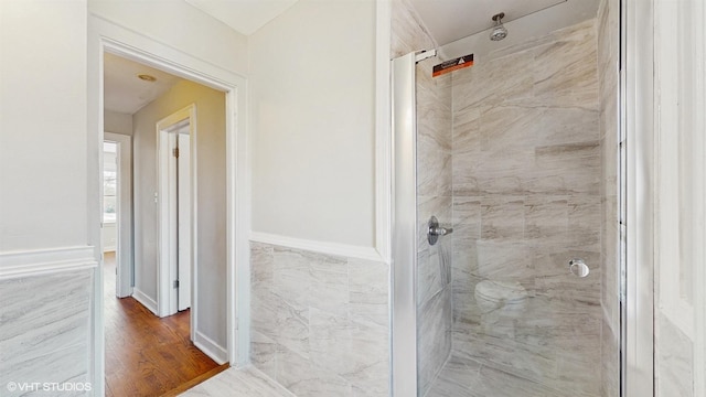 bathroom featuring tiled shower and wood finished floors