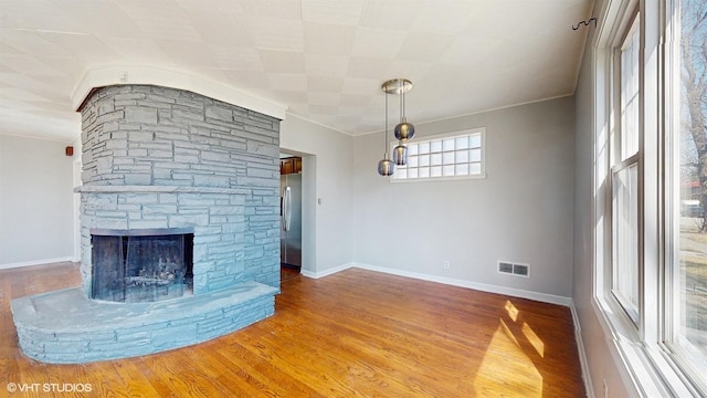 unfurnished living room with baseboards, ornamental molding, and visible vents