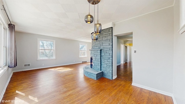 unfurnished living room with baseboards, wood finished floors, and visible vents