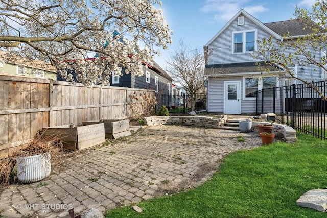 back of property featuring a fenced backyard and a patio