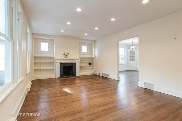 unfurnished living room with recessed lighting, wood finished floors, visible vents, and a fireplace