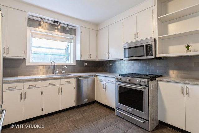 kitchen with white cabinetry, stainless steel appliances, light countertops, and a sink