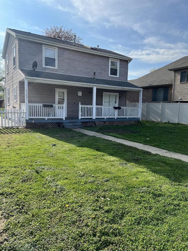 view of front of property with covered porch, fence, and a front lawn
