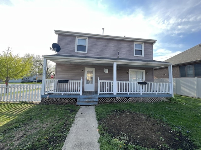 view of front of house with a front lawn, covered porch, and fence