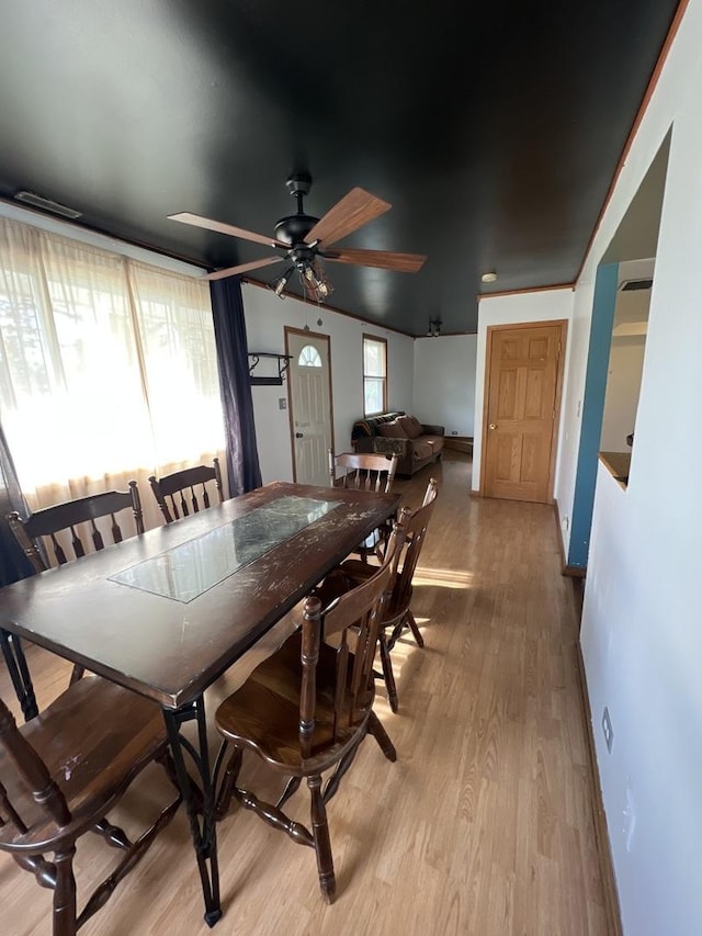 dining room featuring light wood-type flooring and a ceiling fan