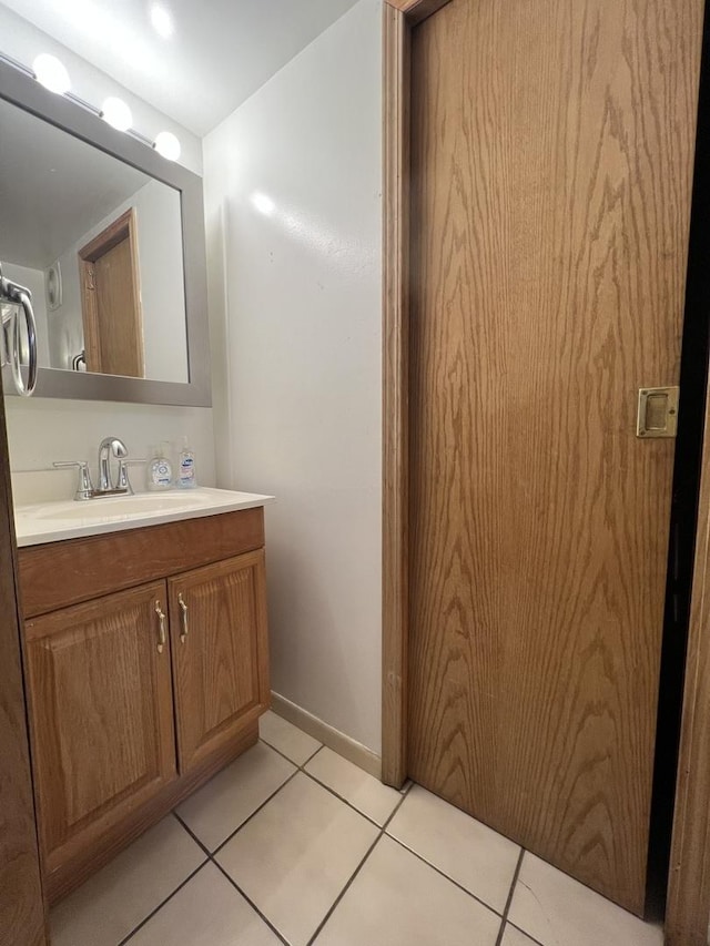 bathroom with tile patterned floors, baseboards, and vanity