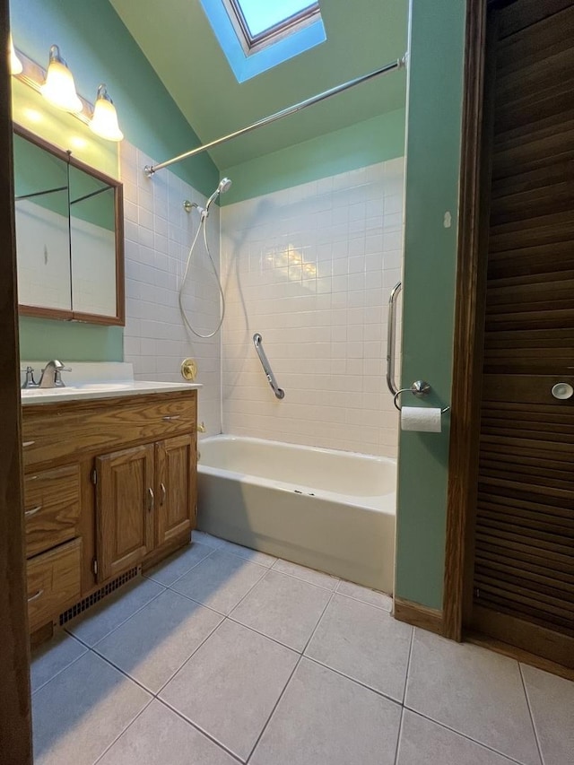 full bathroom featuring tile patterned flooring, vanity, visible vents, lofted ceiling with skylight, and tub / shower combination