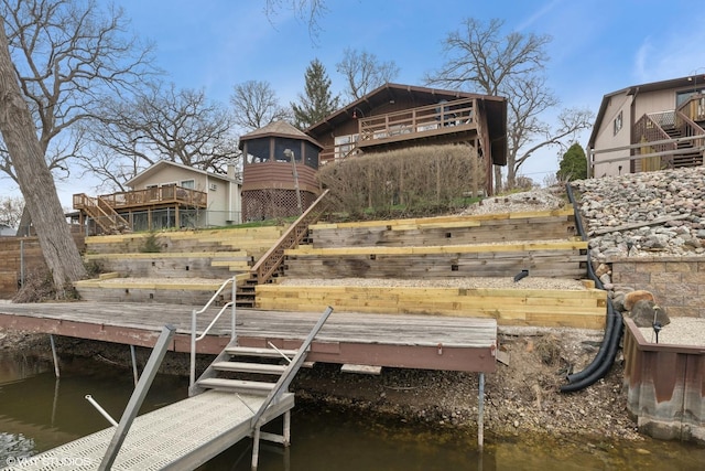 view of dock with a deck with water view and stairway