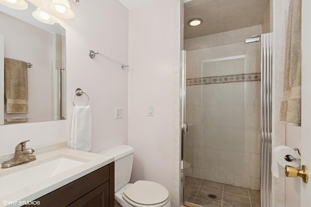 full bath with toilet, vanity, and a stall shower