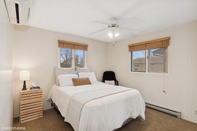 bedroom with a ceiling fan, multiple windows, carpet, and baseboard heating