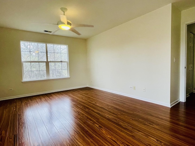 unfurnished room with dark wood-style floors, baseboards, ceiling fan, and visible vents