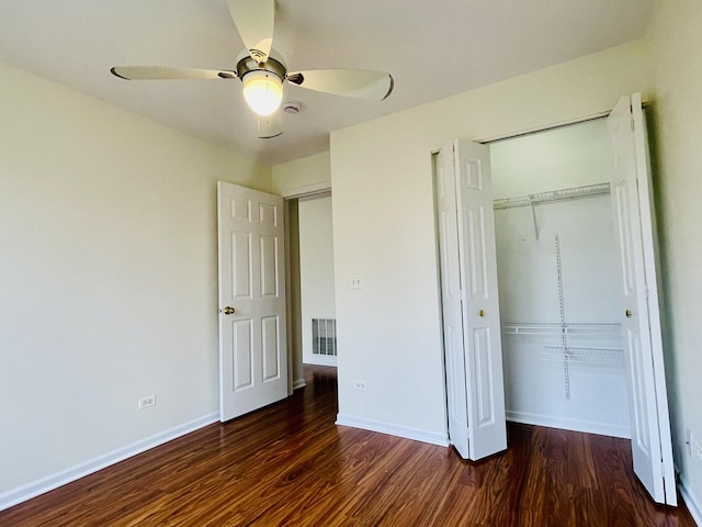 unfurnished bedroom with a closet, wood finished floors, visible vents, and baseboards