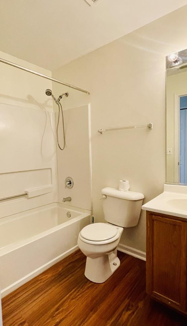 full bathroom featuring wood finished floors, toilet, vanity, and shower / bathtub combination
