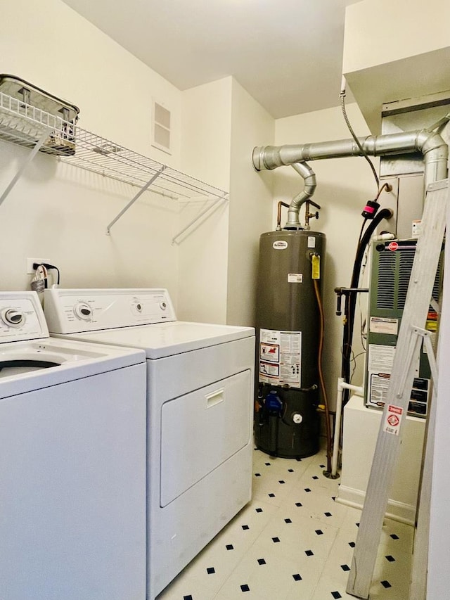 clothes washing area with water heater, light floors, laundry area, visible vents, and washer and dryer