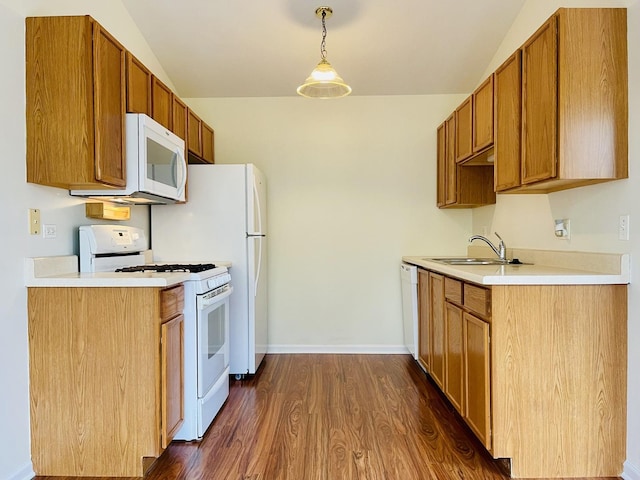 kitchen featuring a sink, white appliances, light countertops, baseboards, and dark wood-style flooring