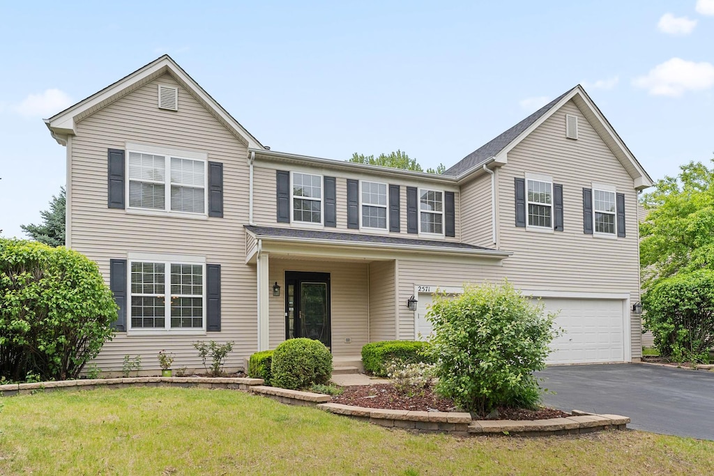 2571 Rourke Dr, Aurora, IL 60503 - traditional-style house with asphalt driveway, an attached garage, and a front yard