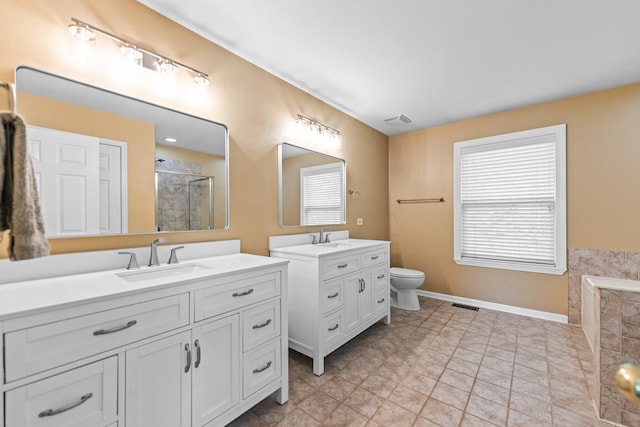 2571 Rourke Dr, Aurora, IL 60503 - bathroom featuring a stall shower, two vanities, toilet, and baseboards