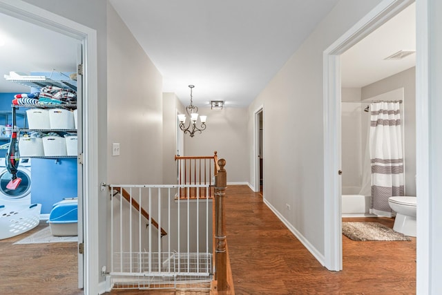 2571 Rourke Dr, Aurora, IL 60503 - hallway featuring an upstairs landing, wood finished floors, a chandelier, and baseboards