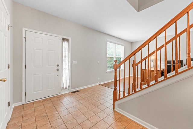 2571 Rourke Dr, Aurora, IL 60503 - entryway with stairway, light tile patterned floors, and baseboards