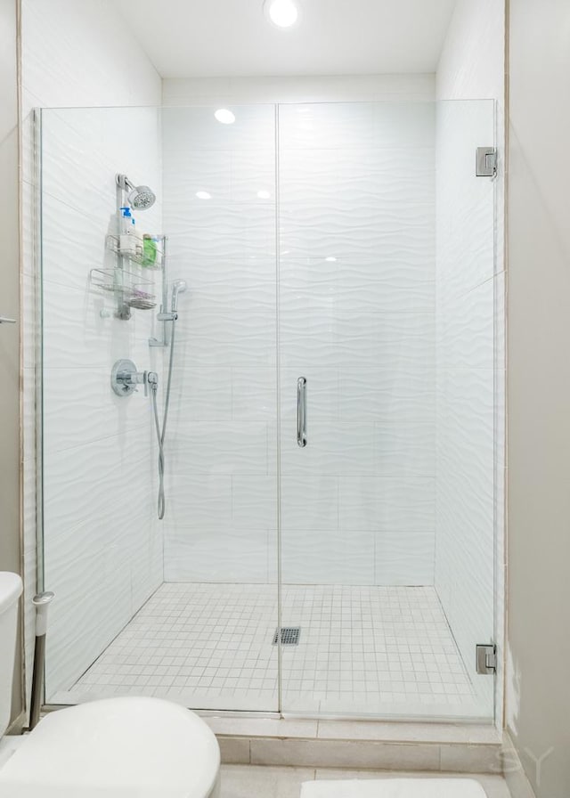 bathroom with toilet and a stall shower