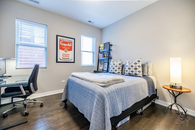 bedroom featuring visible vents, baseboards, and wood finished floors