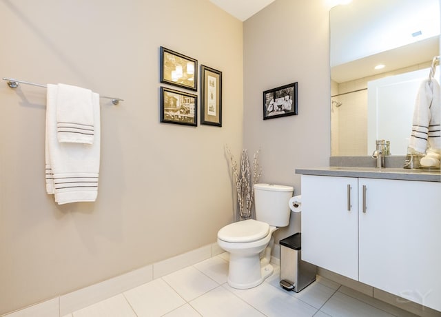bathroom with toilet, tile patterned floors, vanity, and baseboards