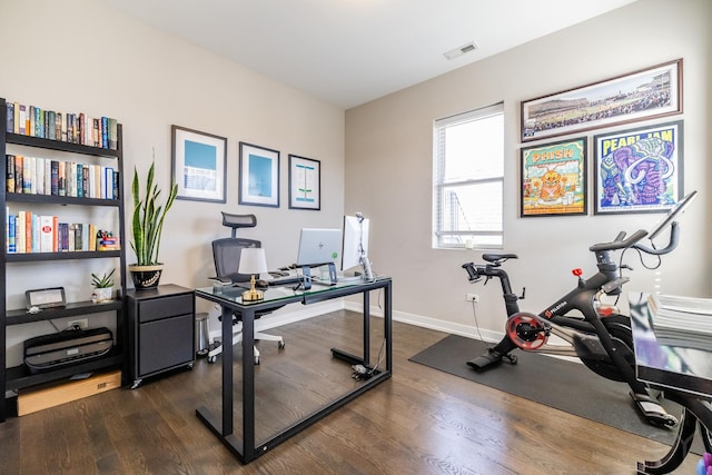 office area featuring dark wood-type flooring, visible vents, and baseboards