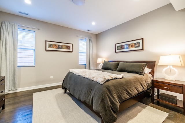 bedroom with visible vents, baseboards, and dark wood finished floors
