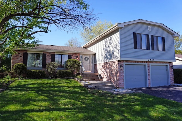 2240 Greenbay Dr, Hanover Park, IL 60133 - split level home with aphalt driveway, a front yard, brick siding, entry steps, and an attached garage