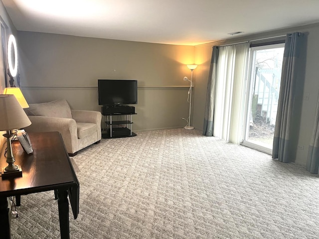 living area with visible vents and carpet flooring