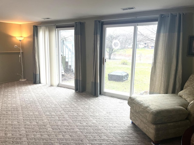 interior space with crown molding, carpet, and visible vents