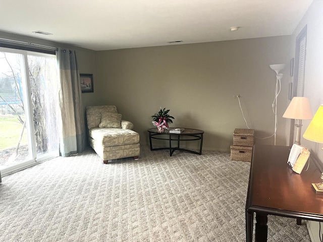 living area featuring visible vents and carpet floors