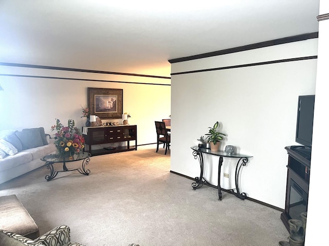 living area featuring crown molding, baseboards, and carpet flooring
